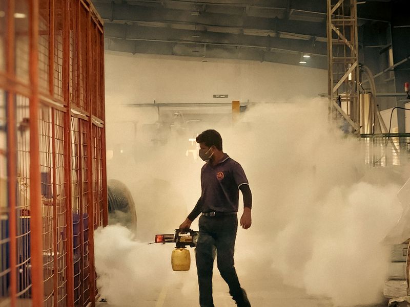 Pest control technician treating a warehouse with a fogging machine