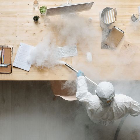 Technician treating an office desk