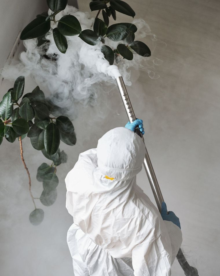 Technician in protective clothing treating a home